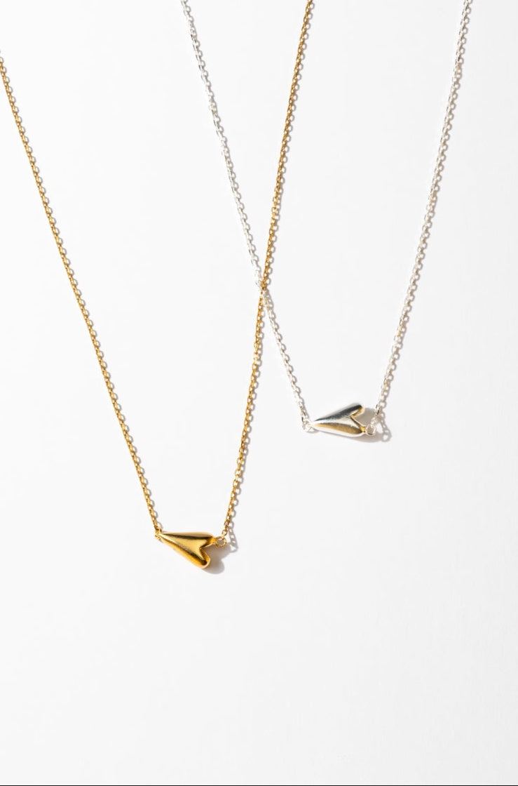 Two gold necklaces with unique pendants on a white background